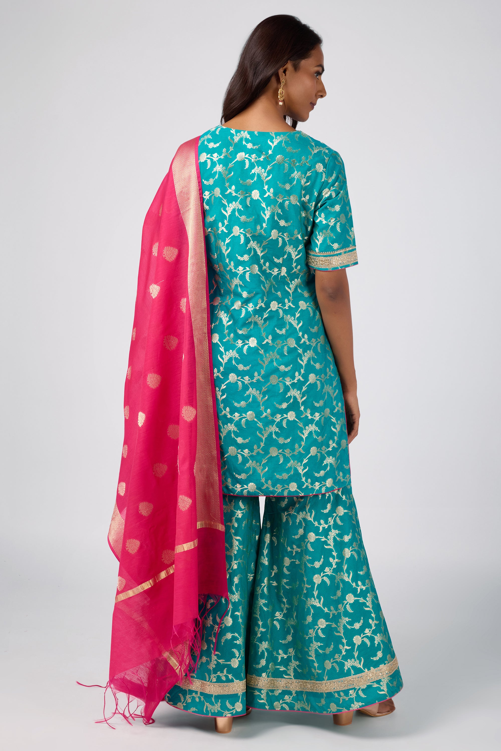 Brocade short V-neck kurti paired with sharara and dupatta.