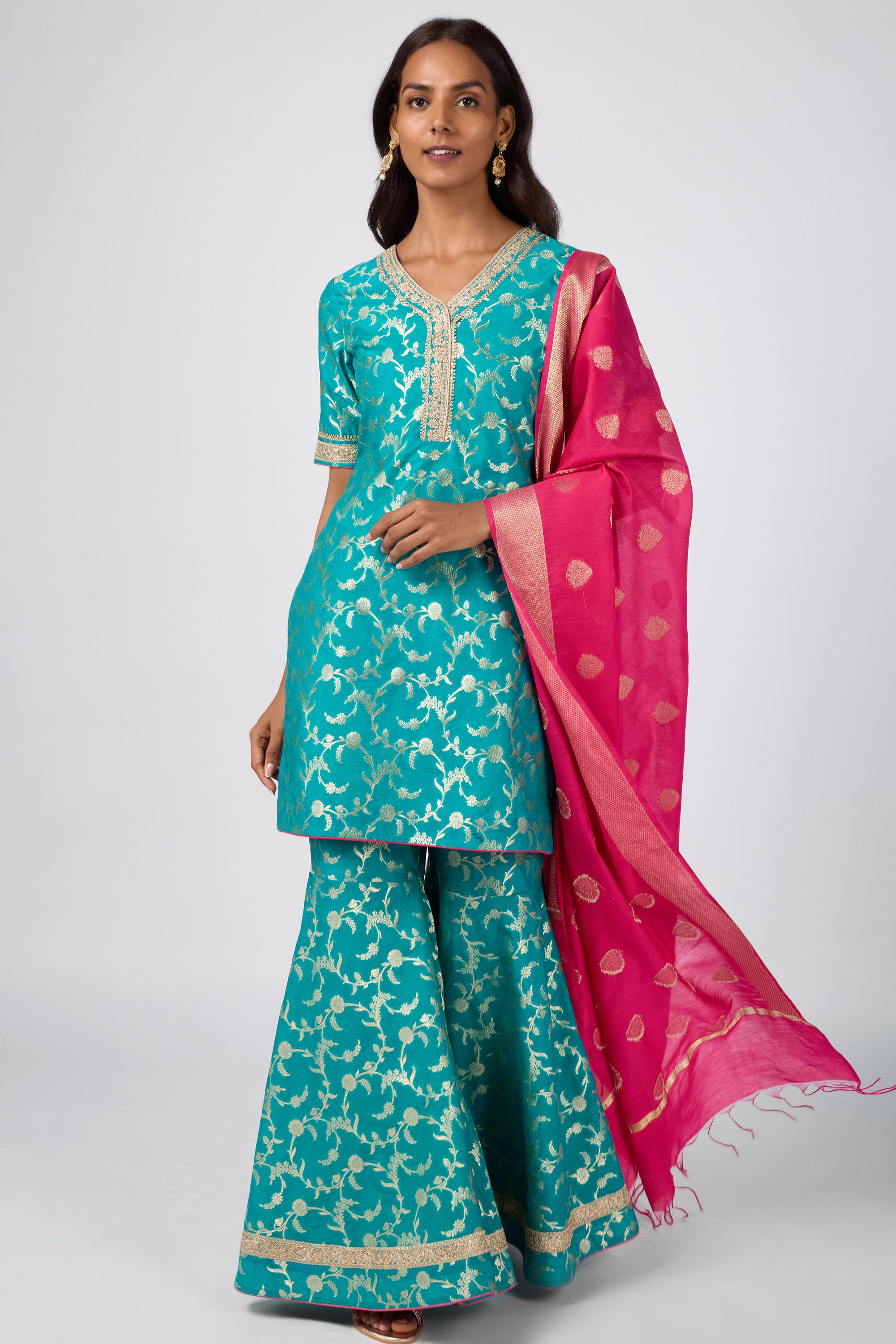 Brocade short V-neck kurti paired with sharara and dupatta.