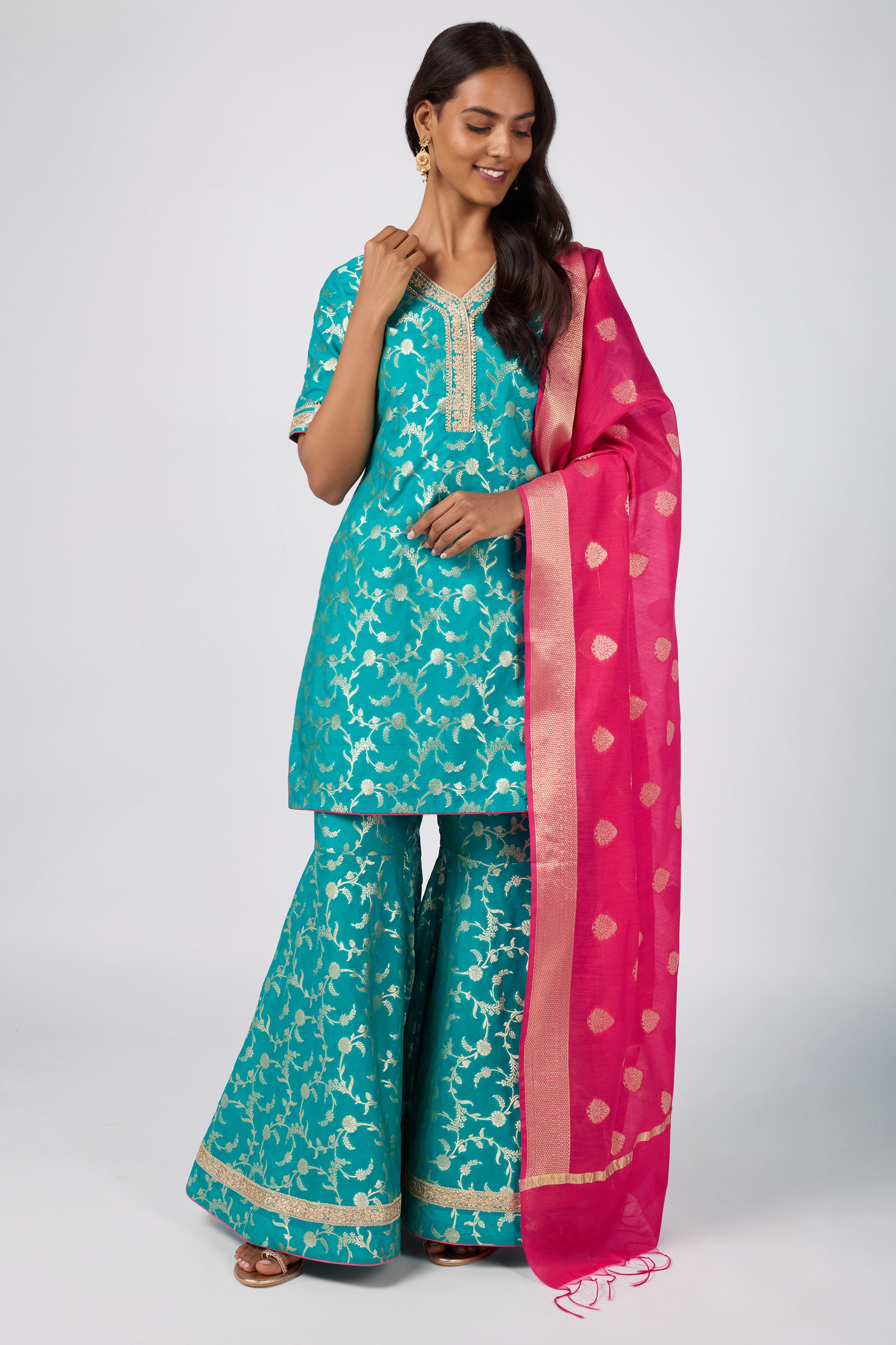 Brocade short V-neck kurti paired with sharara and dupatta.