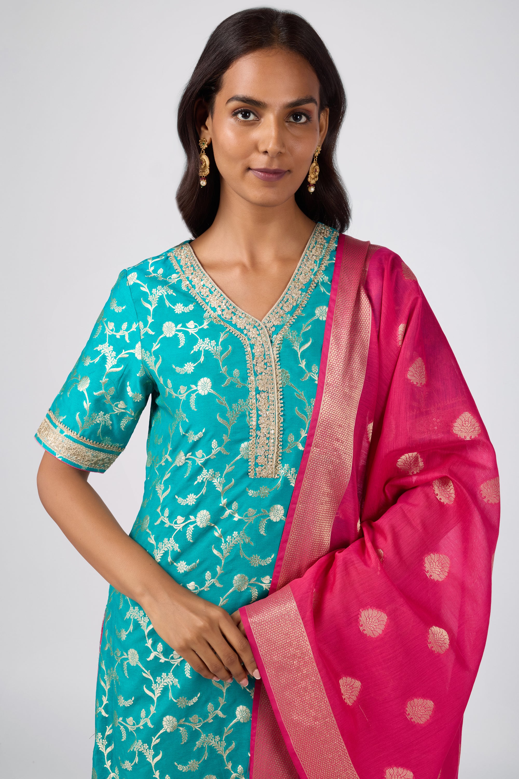 Brocade short V-neck kurti paired with sharara and dupatta.